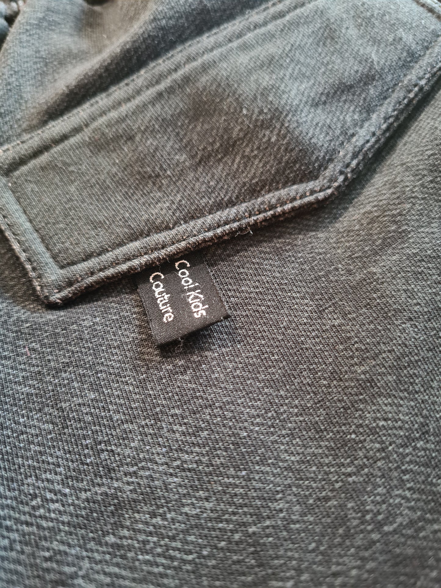 Detailansicht der Gesäßtasche der Jeans aus dem coolen Set für Jungs Gr. 116/122. Hochwertiges Label 'Cool Kids Couture' für einen stylischen Look.