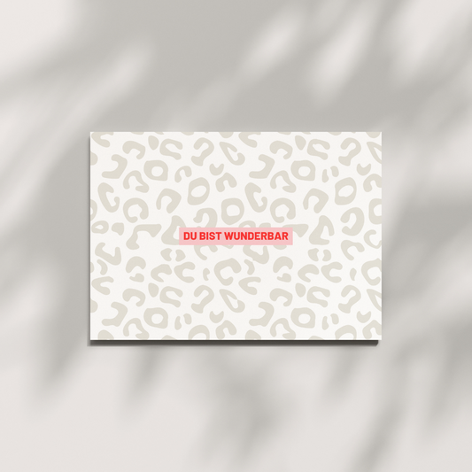 Postkarte Du bist wunderbar in DIN A6 mit Leo Muster und rotem Statement-Text auf 580 g/m² Holzschliffpappe – perfekte Geschenkkarte für Selbstliebe.